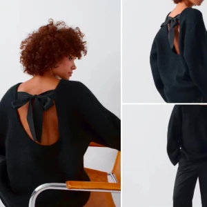 Svart stickad tröja med öppen rygg och rosett - Svart stickad tröja med öppen rygg och en snygg rosettdetalj upptill. Tröjan har lång ärm och en avslappnad passform, perfekt för att lyfta din outfit med en unik touch.