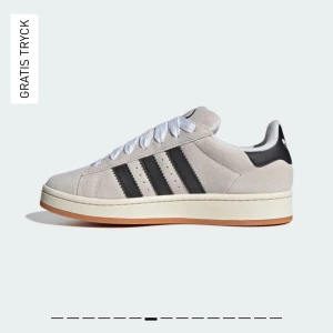 Adidas Campus sneakers i beige och svart - Adidas Campus sneakers i beige mocka med svarta ränder och vit sula. Klassisk låg modell med snörning och gummisula. Säljer då dem tyvärr är förstora för mig. 