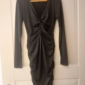 Svart långärmad klänning från Amisu - Säljer en svart långärmad klänning från Amisu i storlek 36. Klänningen har en snygg v-ringning och draperad detalj framtill som ger en smickrande passform. Perfekt för dig som gillar stilrena och eleganta plagg.