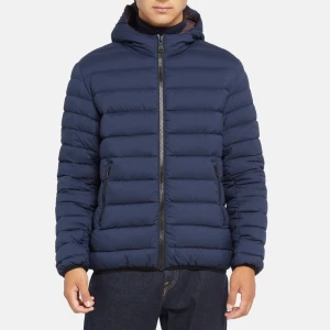 Colmar jacka - Säljer en stilren mörkblå pufferjacka med huva och dragkedja framtill. Jackan har två fickor med dragkedja och quiltad design. Perfekt för kyligare dagar och enkel att matcha med olika outfits. Den är princip ny.