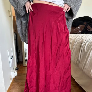 Röd långkjol  - Säljer en röd långkjol från SHEIN i ett mjukt och lätt polyestertyg. Kjolen har en enkel och stilren design utan synliga detaljer och faller snyggt längs benen😍 