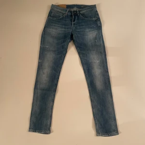 Blå jeans från Dondup - Snygga blå jeans från Dondup med en klassisk femficksdesign. De har en knappgylf och subtila slitningar för en trendig look. Perfekta för en avslappnad stil. Skriv gärna om frågor och pris kan alltid förhandlas! 🤩
