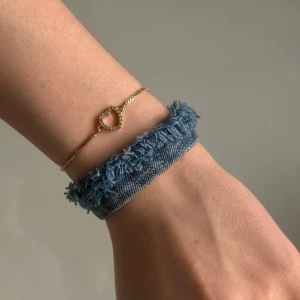 Blått jeansarmband - Unikt armband i ljusblått återvunnet jeansmaterial som även är handgjort och dekorerat med silverfärgade metalldetaljer i rostfritt stål. Armbandet har en justerbar kedja för perfekt passform och själva jeansdelen är 15 cm lång. Kolla gärna in vår instagram: Jeanfluence.uf