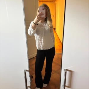 Vit blus med spetsdetaljer - Säljer en söt vit blus med fina spetsdetaljer upptill och på ärmarna. Blusen har lång ärm och en lös, luftig passform. Perfekt att styla med jeans eller kjol för en fräsch look. 🥰💖🌸
