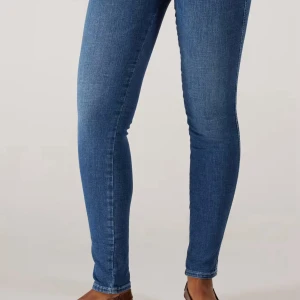 Blå skinny jeans - Säljer ett par klassiska blå skinny jeans med tight passform och normal midja. Perfekta till vardags och lätta att matcha med olika toppar och sneakers.