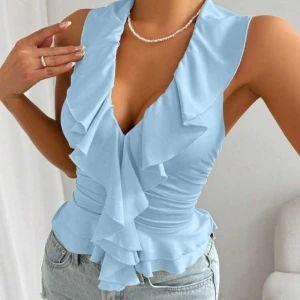 Ljusblå volangtopp med knyt i ryggen - Passar både xs,s och m. Aldrig använd Supersöt ljusblå topp med volangdetaljer framtill och knyt i nacken som ger en öppen rygg. Toppen är figurnära och har en v-ringad design. Perfekt till sommaren och passar till både jeans och kjol.