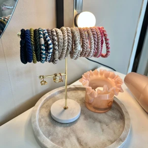 Guldigt smyckesställ med marmorfot - Snyggt smyckesställ i guldmetall med rund vit marmorfot. Perfekt för att hänga upp armband, halsband eller örhängen. Stället har två nivåer för smycken och en stilren design som passar i de flesta rum.