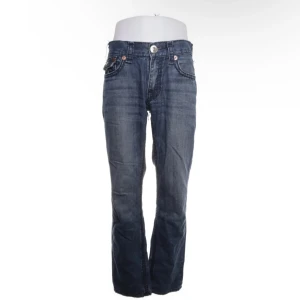 Blå jeansbyxor från True Religion - Säljer ett par klassiska blå jeansbyxor från True Religion. Byxorna har normal passform och raka ben.
