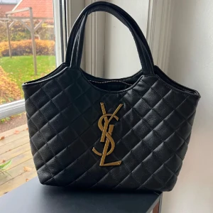 Svart handväska  - Säljer en svart handväska. Väskan har två handtag och medföljer en avtagbar axelrem i kedja med läderdetalj. Väskan är helt ny! 