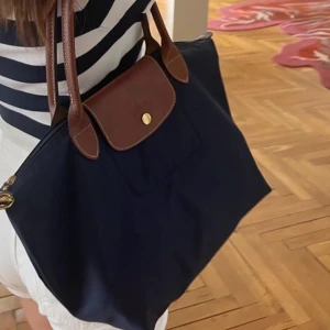 Mörkblå axelväska från Longchamp - Kollar intresset på min mörkblå tote från Longchamp, storlek M. Perfekta väskan för skola eller jobb! Köptes i år på NK och är i mycket fint skick 💙👜