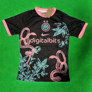 Inter Milan svart fotbollströja med rosa detaljer - Säljer en svart Inter Milan fotbollströja från Nike med rosa och turkosa detaljer. Tröjan har korta ärmar, rosa muddar och krage samt ett unikt mönster med ormar och blad. Digitalbits-logga på bröstet och klubbmärke i mitten.
