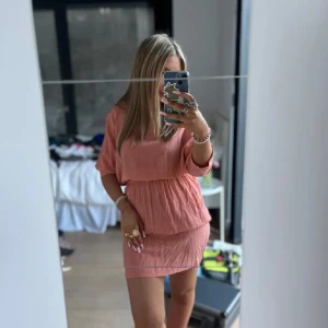 Isabel marant l!kadan - Säljer en ljusrosa kortklänning med lös passform och resår i midjan. Klänningen har korta ärmar och rund halsringning. Perfekt för varma dagar och enkel att styla med smycken eller sneakers.