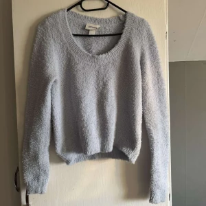 Ljusblå fluffig tröja från Monki - Supermjuk och fluffig ljusblå tröja från Monki med v-ringning och lång ärm. Storlek M men känns som S
