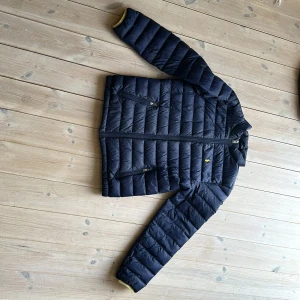 Polo lättvikts jacka. 14-16 år (160)  - En marinblå polo, lättvikts jacka i fint skick. En liten liten reva på kragen bak. Har inte provat att laga, går säkert att sy ihop eller limma. 