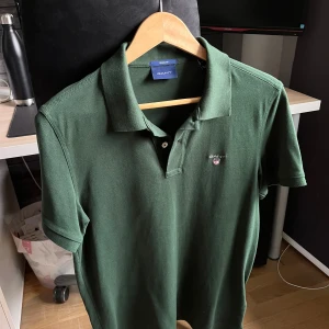 Grön pikétröja från GANT - Säljer en stilren grön pikétröja från GANT i storlek M. I nyskick