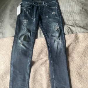 Mörkblå Dondup destroyed - Snygga mörkblå jeans från Dondup med en riktigt fet tvätt och slitningar. Tags finns kvar och jeansen har nästan inga tecken på användning.