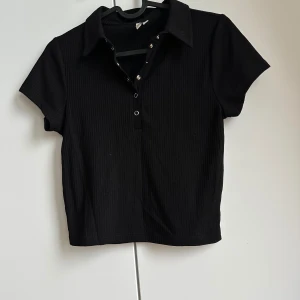 Crop top - Ribbad crop top med krage och knappar.