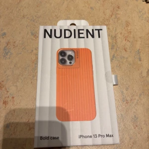 Orange mobilskal - Nudient - Säljer ett snyggt orange mobilskal från Nudient för iPhone 13 Pro Max. Skalet har en stilren design med ribbad yta. Ej använd, helt ny. 