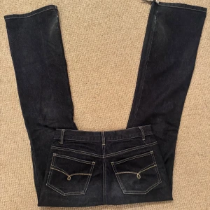 Svarta jeans - Snygga svarta jeans med fina detaljer på fickorna. De är i storlek 34 och sitter super fint. Har tyvärr fått slitningar där nere, därav priset❤️