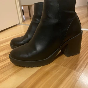 Svarta boots med klack - Snygga svarta ankelboots med klack.  Finns en nötning framtill som jag tagit närbild på (bild 3). Har även tagit en bild på håll, tycker själv att det inte är något som stör. I övrigt är dom i fint skick!