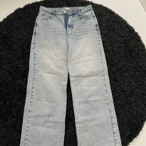 Ljusblå jeans från Gina Tricot  - Snygga ljusblå jeans från Gina Tricot med en klassisk femficksdesign. De har en rak passform och är perfekta för en avslappnad stil. Jeansen har en knapp- och dragkedjestängning framtill.