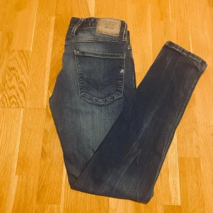 Mörkblå jeans från Replay - Snygga mörkblå jeans från Replay i model ambass. Jeansen har en normal passform och är tillverkade i ett slitstarkt denimtyg. Perfekta för en grisch stil. Priset kan gå ner. W31 L34