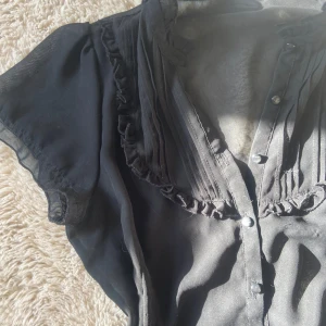 Svart blus - Jättefin svart blus perfekt till alla olika möjliga tillfällen. Knappar så man kan välja hur mycket man vill att den ska vara uppknäppt