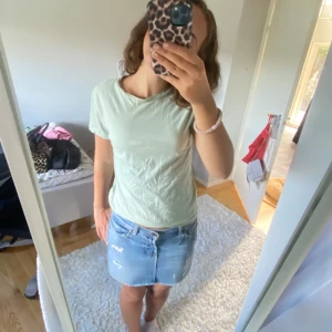 Ljusgrön t-shirt - Säljer en ljusgrön t-shirt med korta ärmar och rund hals. Perfekt för en avslappnad stil.