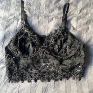 Svart spets topp från Shein - Säljer en svart spets toop från Shein. Den har justerbara axelband och vacker spetsdetaljering runt om. Aldrig använd då den är för liten. Mer som en S i storleken. Passar inte någon med stor byst. 