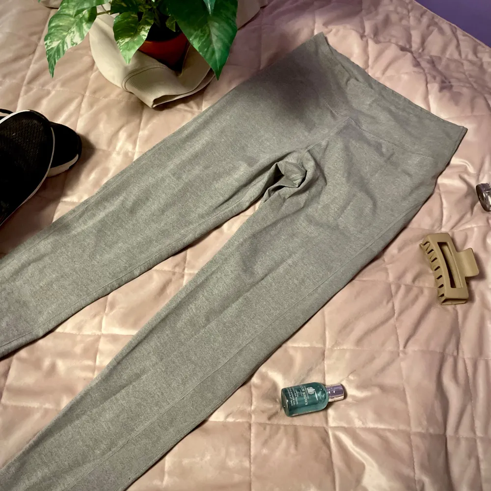 Snygga grå träningsleggings med hög midja. Perfekta för en avslappnad stil eller träning. De är tillverkade i ett mjukt och stretchigt material som ger en bekväm passform. Skulle säga storleken är M/L, lite mindre i storleken. Perfekt till allt mellan yogging och yoga!. Sportswear.