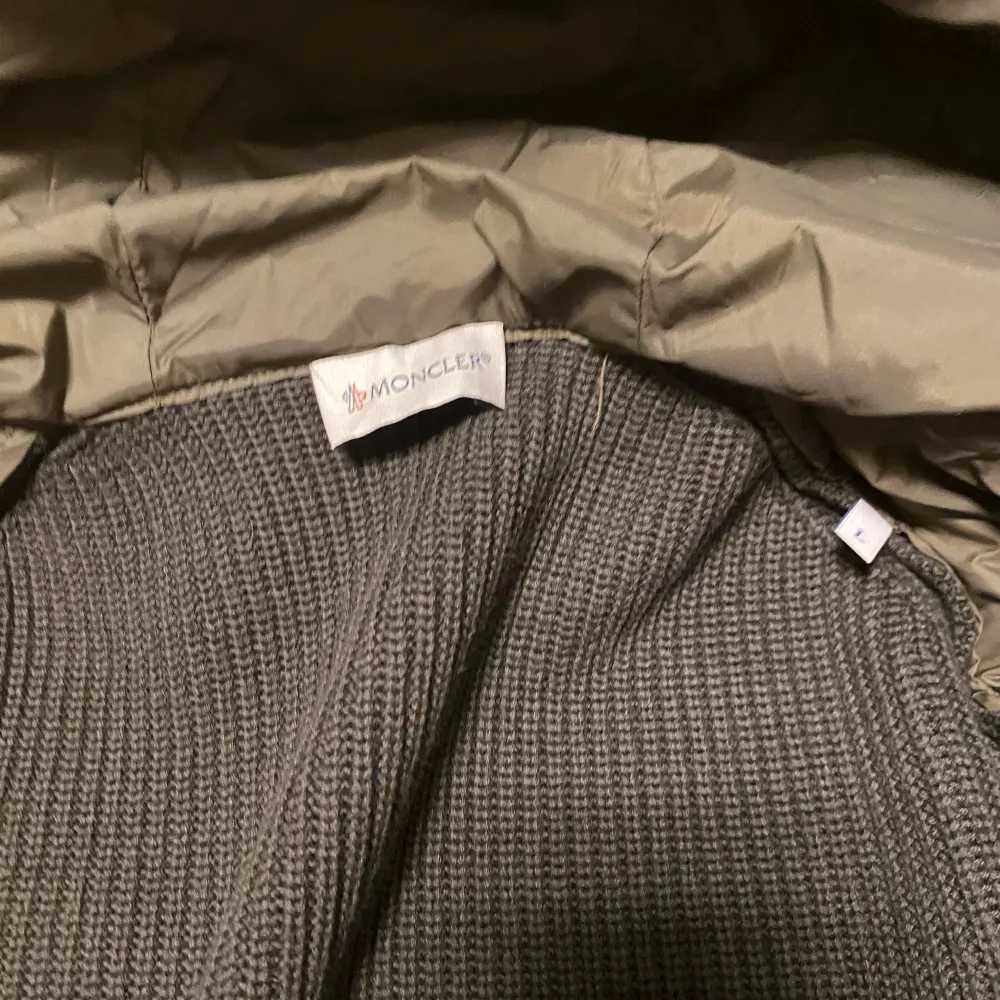 Snygg olivgrön jacka från Moncler med quiltad design och huva. Jackan har långa ärmar i ribbat material och dragkedja framtill. Perfekt för kyligare dagar. Jackan är i storlek L men sitter lite tajt så skulle nog säga att den passar mer som M. Har du minsta lilla fundering så är det bara att fråga på.. Takit.