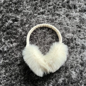 Vita pälsöronmuffar - Säljer ett par fluffiga vita öronmuffar med päls. Perfekta för att hålla värmen under kalla dagar. De har en mjuk och bekväm passform.