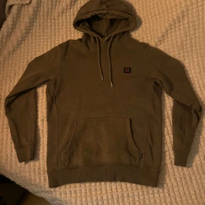 Mörkgrön Les Deux hoodie - Säljer min mörkgröna Les Deux hoodie, då jag inte längre använder den. Jag har haft den ett tag men har inte använt den mycket. Skicket på tröjan är jättebra, då den inte har några fläckar eller hål eller liknande.  Det är storlek S, men skulle nog även passa XS. 