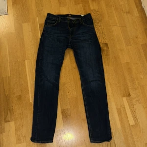 Mörkblå jeans från Lee - Snygga mörkblå jeans från Lee med klassisk femficksdesign. De har en straight passform och är tillverkade i slitstarkt denim. Perfekta för en avslappnad stil.