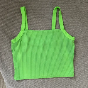 Grön ribbad linnetopp - Säljer en snygg grön ribbad linnetopp med smala axelband. Perfekt för varma dagar och en färg som verkligen sticker ut. Passar bra till både jeans och kjol. 🌿