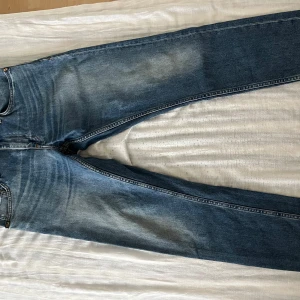 Blå jeans från Tiger of Sweden - Snygga blå jeans från Tiger of Sweden med klassisk design. De har en rak passform och är tillverkade i slitstarkt denim. Perfekta för en stilren look.
