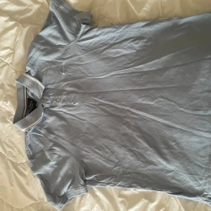 Ljusblå pikétröja från Jack & Jones - Säljer en ljusblå pikétröja från Jack & Jones med klassisk krage och knappar framtill. Perfekt för en avslappnad och stilren look. Kortärmad modell i mjukt material.