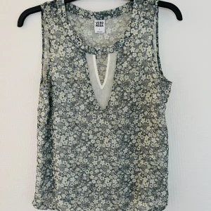 Topp utan ärmar  - Topp/ blus utan ärmar. Fodrad/dubbel på framsidan med inre créme-färgat tyg. Luftig modell med fina detaljer fram, se bilder. Polyester  Vero Moda #lena6800toppar St. S, rejäl i storleken och passar även M. Endast tagg bortklippt. Aldrig använd.