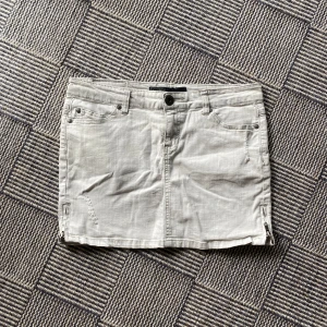 Grå / Vit  jeanskjol från ONLY - Säljer en ljusgrå / vit jeanskjol från ONLY Limitless Denim. Kjolen har klassisk femficksdesign, knapp och dragkedja framtill samt små dragkedjedetaljer i sidorna. Perfekt för dig som gillar en enkel och stilren look! Vintage. Midjemått : 40 cm / W30