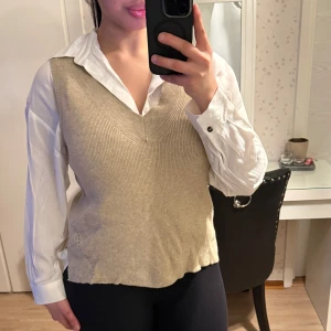 Beige stickad väst från Vila - Säljer en beige stickad väst från Vila med v-ringning och fina, diskreta detaljer i sidorna. Mjuk, bekväm och perfekt att slänga över en skjorta eller topp. Har små slitsar i sidorna som ger en snygg passform.  Använd få gånger och i fint skick. Pris kan diskuteras 💕 Skriv om du vill ha fler bilder!