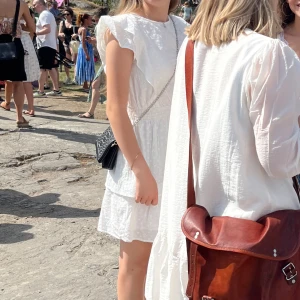 Vit  klänning från VILA - Superfin vit klänning från VILA med volanger. Parefect för misssomar och skolavslutning. Bara använd en gång. Nypris 600kr