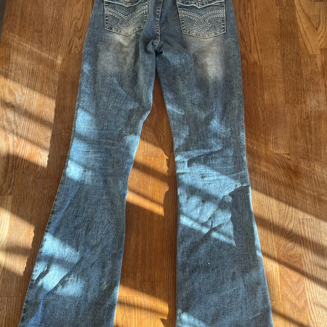 Blå bootcut jeans med broderade bakfickor
