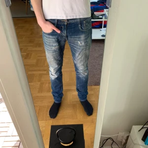 Blå replay jeans med slitningar - Ett par riktigt feta replay jeans med slitningar. Modellen är anbass och passformen är slim fit.