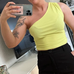 Gul ribbad oneshoulder topp från SHEIN - Snygg ljusgul croppad topp från SHEIN i ribbat material. Modellen är oneshoulder och sitter tight. Perfekt för dig som vill sticka ut med en färgglad och trendig topp!