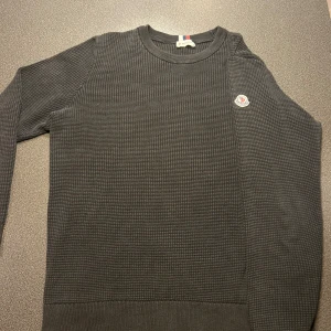 Svart stickad tröja från Moncler - Säljer en svart stickad tröja från Moncler med diskret Moncler-logga på armen. Perfekt för dig som gillar stilrena och exklusiva plagg. Vid frågor eller funderingar är det bara att höra av sig! M men sitter lite åt S hållet.