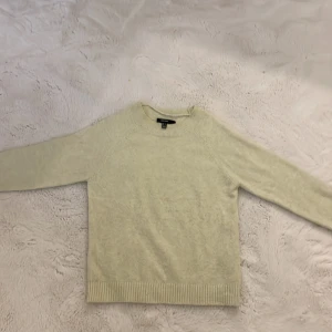 Pastellgul stickad tröja från Vero Moda - Mysig pastellgul stickad tröja från Vero Moda med rund halsringning och ribbade muddar vid ärmslut och nederkant. Perfekt för lager-på-lager och enkel att matcha med olika outfits.