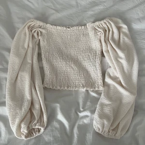 Vit blus från BikBok - Säljer en vit blus med ballong armar och tight vid midjan. 