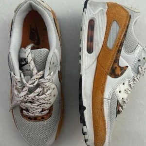 Nike Air Max 90 i vitt och brunt - 🇸🇪Säljer ett par Nike Air Max 90 med vit mesh, bruna mockadetaljer och genomskinlig sula. Skorna har snörning med vita skosnören med svarta prickar och klassisk Air Max-dämpning. Perfekta för dig som gillar streetwear och snygga sneakers.🇫🇮Käytetty pari kertaa, liian pienet.