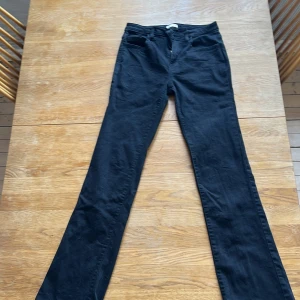 Svarta bootcut jeansbyxor - Svarta jeansbyxor med bootcut-passform och klassiska fem fickor. Byxorna har dragkedja och knapp framtill och är tillverkade i ett mjukt denimtyg. Perfekta för dig som gillar en tidlös och enkel stil.. används 1 gång då de är för stora.💕💕