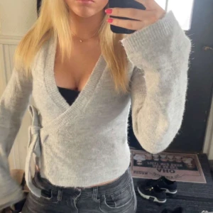 Grå omlottkofta 🩶 - Grå omlott kofta från Gina tricot. Den ör i jätte bra skick använd ett få tal gånger. Skriv för fler bilder eller om ni har fler frågor💝